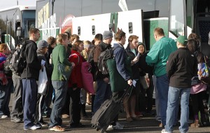A trip leader checks in a line of Baylor students as they load buses on campus Wednesday morning before heading for San Diego to cheer the Bears at the Holiday Bowl.Paul Carr / Baylor Student Publications