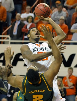 Oklahoma State guard Marcus Smart, top, is fouled by Baylor forward Rico Gathers (2) during the second half of an NCAA college basketball game in Stillwater, Okla., Wednesday, Feb. 6, 2013. Smart scored 14 points in the Oklahoma State 69-67 overtime win over Baylor. 