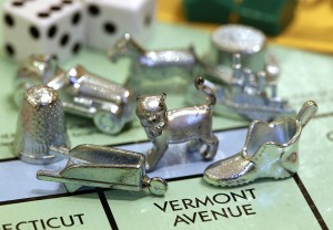 The newest Monopoly token, a cat, center, rests on a Boardwalk deed next to other tokens still in use including the wheelbarrow, left, and the shoe, right, at Hasbro Inc. headquarters, in Pawtucket, R.I., Tuesday, Feb. 5, 2013.  Voting on Facebook determined that the cat would replace the iron token.  Associated Press