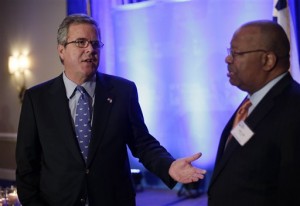 Jeb Bush, left, talks to businessmen prior to addressing the Texas Business Leadership Council, Tuesday, Feb. 26, 2013, in Austin, Texas. Bush said Tuesday night that America spends more on public education than any other country and yet about a third of students aren't ready for college when they graduate high school. (AP Photo/Eric Gay)