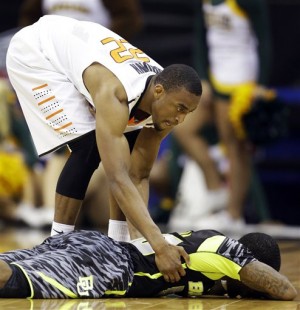Oklahoma State guard Markel Brown (22) helps up Baylor guard Pierre Jackson (55) following an NCAA college basketball game in the Big 12 tournament, Thursday, March 14, 2013, in Kansas City, Mo. Jackson had just missed a last-second basket. Oklahoma State won 74-72. (AP Photo/Orlin Wagner)
