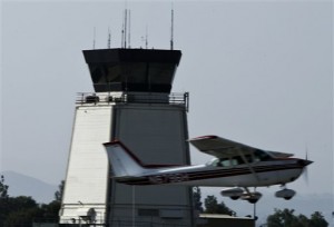 In this March 21, 2013 photo, A plane passes the control tower at Riverside Municipal Airport in Riverside, Calif. Eleven air traffic control towers at small airports throughout California are on the Federal Aviation Administration's list of nationwide facilities to be closed next month due to spending cuts. (AP Photo/Los Angeles Times, Mark Boster)