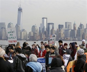 FILE - In this Feb. 13, 2013, file photo, before the New York skyline, a group of immigrant rights advocates gather near Ellis Island in Liberty State Park, Jersey City, N.J. A dispute between business and labor groups over wages for low-skilled workers is a final issue holding up a deal on a sweeping immigration bill in the Senate on Friday, March 22, 2013. (AP Photo/Mel Evans, file)