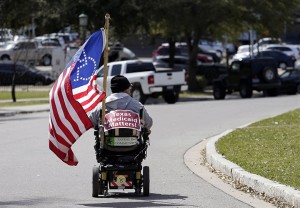 Protester Danny Saenz drives his wheel chair on the grounds of the the Texas capitol, Tuesday, March 5, 2013, in Austin, Texas. Protesters demand that lawmakers expand Medicaid to include an additional 1.5 million poor people. (AP Photo/Eric Gay)