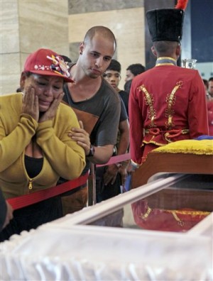 In this photo provided by Miraflores Presidential Press Office, mourners pay their respects as they file past the glass-topped casket containing the remains of Venezuela's late President Hugo Chavez lying in state at the military academy in Caracas, Thursday, March 7, 2013. Chavez died of a massive heart attack Tuuesday after great suffering and inaudibly mouthed his desire to live, the head of Venezuela's presidential guard said late Wednesday.  (AP Photo/Miraflores Presidential Press Office)