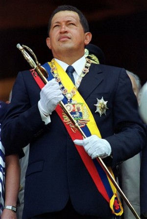 FILE - In this July 24, 2000 file photo, Venezuela's President Hugo Chavez holds Simon Bolivar's sword at an event celebrating the independence hero's 114th birthday in Caracas, Venezuela. Venezuela's Vice President Nicolas Maduro announced on Tuesday, March 5, 2013 that Chavez has died.  Chavez, 58, was first diagnosed with cancer in June 2011.  (AP Photo/Andres Leighton, File)