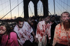 FILE - Costumed actors, promoting the Halloween premiere of the AMC television series "The Walking Dead", shamble along the Brooklyn Bridge while posing for pictures in New York, in this Oct. 26, 2010 file photo. Clemson University English professor Sarah Lauro says people are more interested in zombies when they're dissatisfied with society as a whole. As of last year, Lauro said, zombie walks had been documented in 20 countries. The largest gathering drew more than 4,000 participants at the New Jersey Zombie Walk in Asbury Park, N.J., in October 2010, according to the Guinness World Records. (AP Photo/Seth Wenig, File)
