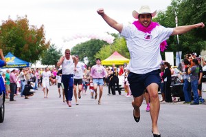 A man celebrates as he crosses the finish line while his fellow runners push themselves to the end in the 2012 Stiletto Stampede.  (Courtesy Photo)