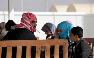 A newly-arrived Syrian refugee family waits under a shaded area upon their arrival to the new Jordanian-Emirati refugee camp, Mrajeeb al-Fhood, in Zarqa, Jordan, Wednesday, April 10, 2013. A second camp for Syrian refugees has opened in Jordan as more Syrians flee the civil war at home. The Jordanian-Emirati camp is the first funded by the United Arab Emirates and run by its Red Crescent Society in Jordan to assist families, single women, the disabled, and elderly.(AP photo/Mohammad Hannon)