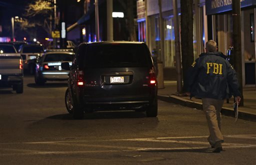 An FBI official arrives at the Watertown neighborhood of Boston, Friday, April 19, 2013. Reports of explosives being detonated and police are telling reporters to turn off their cell phones. Dozens of officers and National Guard members are in Watertown, where television outlets report that gunfire and explosions have been heard. (AP Photo/Julio Cortez)