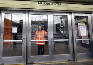 An MBTA transit official closes a door at Malden Center station in Malden, Mass. Friday, April 18, 2013 as area MBTA commuter trains are suspended. Two suspects in the Boston Marathon bombing killed an MIT police officer, injured a transit officer in a firefight and threw explosive devices at police during their getaway attempt in a long night of violence that left one of them dead and another still at large Friday, authorities said as the manhunt intensified for a young man described as a dangerous terrorist. (AP Photo/Elise Amendola)