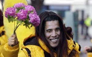 An activist from Amnesty, wearing a mask of U.S. President Barack Obama, holds flowers during a campaign in Seoul, South Korea, ahead of negotiations of the U.N. Arms Trade Treaty in New York, Monday, March 18, 2013. The activists demanded to stop selling weapons to corporate human rights abusers. (AP Photo/Lee Jin-man)