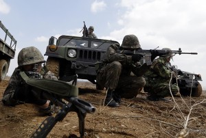 South Korean Army soldiers aim their machine guns, along with U.S. Air Force's Airman First Class, Lee Simpson from Sportanburg, South Carolina, top on a humvee, during a joint military drill between South Korea and the United States to protect U.S. air base near the Osan U.S. Air Base in Pyeongtaek, south of Seoul, South Korea, Thursday, March 14, 2013.  In recent days, North Korea has vowed "merciless" retaliation and said it will no longer abide by the armistice that ended the Korean War. Pyongyang is angry about ongoing U.S.-South Korean military drills and about new U.N. sanctions, issued over the North's December long-range rocket launch, which the U.N. called a cover for a banned missile test, and its third underground nuclear explosion, conducted Feb. 12. (AP Photo/Lee Jin-man)