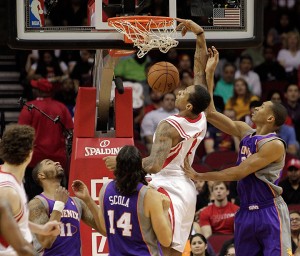 Houston Rockets forward Greg Smith (4) dunks on Phoenix Suns forwards Wesley Johnson (2) and Luis Scola (14) during the first half of an NBA basketball game Tuesday, April 9, 2013, in Houston. (AP Photo/Bob Levey)