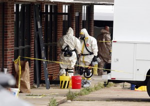 Federal authorities, some in hazmat suits, walk outside the staging area as they search at a small retail space where neighboring business owners said Everett Dutschke used to operate a martial arts studio, in connection with the recent ricin attacks, Wednesday, April 24, 2013 in Tupelo, Miss. No charges have been filed against Dutschke and he hasn’t been arrested. (AP Photo/Rogelio V. Solis)
