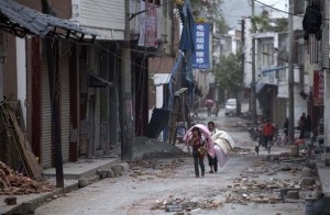 In this photo released by China's Xinhua news agency, people carrying their belongings walk in quake-damaged Gucheng Village, Longmen Township, Lushan County, southwest China's Sichuan Province, Saturday, April 20, 2013. A powerful earthquake struck the steep hills of Sichuan province Saturday, nearly five years after a devastating quake wreaked widespread damage across the region. (AP Photo/Xinhua, Fei Maohua)