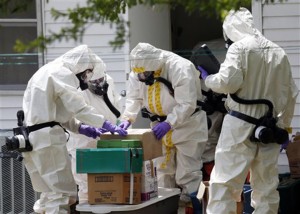 Federal agents wearing hazardous material suits and breathing apparatus inspect the home and possessions in the West Hills Subdivision house of Paul Kevin Curtis in Corinth, Miss., Friday, April 19, 2013. Curtis is in custody under the suspicion of sending letters covered in ricin to the U.S. President Barack Obama and U.S. Sen. Roger Wicker, R-Miss. (AP Photo/Rogelio V. Solis)
