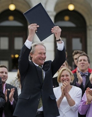 Rhode Island Gov. Lincoln Chafee holds up a a gay marriage bill after signing it into law outside the State House in Providence, R.I., Thursday, May 2, 2013. (AP Photo/Charles Krupa)