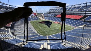 A clear plastic bag measuring about a foot square is held up in Gillette Stadium prior to NFL football training camp in Foxborough, Mass., Wednesday, Aug. 14, 2013. The bag is approved under the NFL's new stadium bag policy, which limits the size to 12 inches square and 6 inches deep; the bag must be clear. Small clutch bags are also permitted. (AP Photo/Charles Krupa)