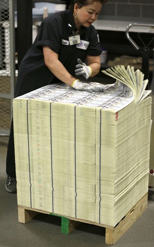A stack of uncut sheets of $100 bills are inspected before being moved during the printing process at the Bureau of Engraving and Printing Western Currency Facility in Fort Worth, Texas, Tuesday, Sept. 24, 2013.  The federal printing facility is making the new-look colorful bills that include new security features in advance of the Oct. 8 circulation date.  (AP Photo/LM Otero)
