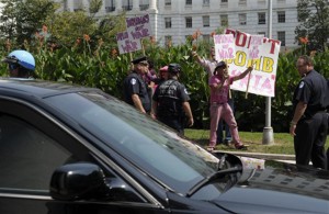 Protestors shout as a vehicle with Secretary of State John Kerry departs Capitol Hill in Washington, Tuesday, Sept. 10, 2013, after Kerry testified before the House Armed Services Committee hearing on Syria. (AP Photo/Susan Walsh)