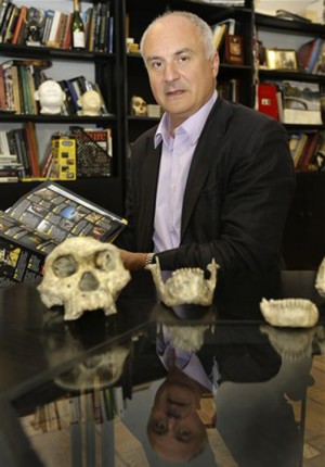 In this photo taken Oct. 2, 2013, David Lordkipanidze, director of the Georgia National Museum, displays the ancient skull and jaws of a pre-human ancestor at the National  Museum in Tbilisi, Georgia, Wednesday, Oct. 2, 2013. The discovery of a 1.8-million-year-old skull of a human ancestor found below Dmanisi, a medieval Georgian village, captures early human evolution on the move in a vivid snapshot and indicates our family tree may have fewer branches than originally thought, scientists say. (AP Photo/Shakh Aivazov)