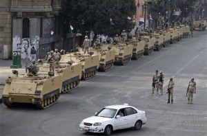 FILE - In this Friday, Aug. 16, 2013, file photo, Egyptian army soldiers take their positions on top and next to their armored vehicles to guard an entrance of Tahrir Square, in Cairo. U.S. officials said Wednesday, Oct. 9, 2013, that the Obama administration is poised to slash hundreds of millions of dollars in military and economic assistance to Egypt. The U.S. has been considering such a move since the Egyptian military ousted the countryís first democratically elected leader in June. (AP Photo/Hassan Ammar, File)