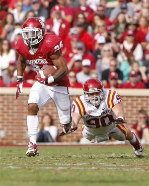 Oklahoma senior running back Brennan Clay runs past a diving tackle attempt from Iowa State freshman defensive end Mitchell Meyers in Oklahoma’s 48-10 victory on Saturday in Norman, Okla. (Alonzo Adams | Associated Press)
