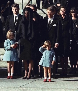 FILE - In this Monday, Nov. 25, 1963 file photo, 3-year-old John F. Kennedy Jr. salutes his father's casket in Washington, three days after the president was assassinated in Dallas. Widow Jacqueline Kennedy, center, and daughter Caroline Kennedy are accompanied by the late president's brothers Sen. Edward Kennedy, left, and Attorney General Robert Kennedy. (AP Photo/File)