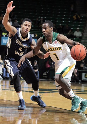 Baylor junior guard Kenny Chery dribbles by Charleston Southern senior guard Sheldon Strickland on Wednesday at the Ferrell Center. Baylor defeated Charleston Southern 69-64 to move to 4-0 on the season.  Travis Taylor | Lariat Photo Editor