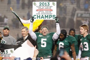 Senior linebacker Eddie Lackey holds up a ‘2013 Big 12 Champs’ sign on top of the podium at Floyd Casey         Stadium on Saturday after Baylor defeated Texas 30-10 to clinch the Big 12 Championship outright.  Robby Hirst | Lariat Photographer