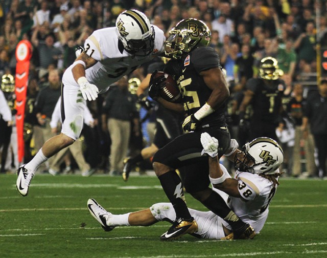 No. 25 junior running back Lache Seastrunk is tackled by UCF No. 31 linebacker Sean Maag and No. 38 cornerback Jordan Ozerities during the Fiesta Bowl game on Wednesday, Jan. 1, 2014, at the University of Phoenix Stadium in Glendale, Ariz. Drew Mills | Round Up Photographer