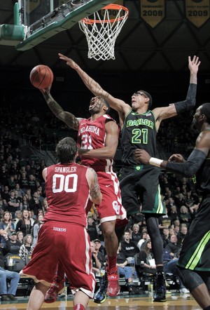 Sophomore center Isaiah Austin tries to block the shot of Oklahoma's senior forward Cameron Clark during the second half of Baylor's 66-64 loss to Oklahoma.  Austin finished the game with 12 points and nine rebounds.   Travis Taylor | Lariat Photo Editor
