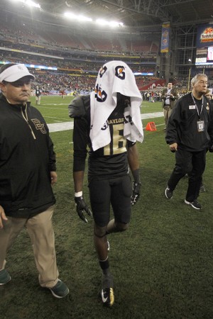 No. 16 senior receiver Tevin Reese exits the field with a towel over his head after the Bears suffered a devasting 52-42 loss to the UCF Knights in the Fiesta Bowl at the University of Phoenix Stadium in Glendale, Ariz. on Wednesday, Jan. 1, 2014. Matt Hellman | Lariat Multimedia Producer