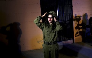 In this Wednesday, Jan. 29, 2014 photo, Fayka al-Najar, who plays an Israeli female soldier, adjusts her hat on the set of a movie being made in Gaza called, '' Losing  Shalit,'' adjusts her hat during filming in Gaza City. "Losing Schalit," currently being filmed in the blockaded territory, is the first of a planned three-part series about the 2006 capture of Israeli soldier Gilad Schalit by gunmen allied with the Islamic militant Hamas movement. Parts two and three will depict Schalit's time in captivity and his 2011 swap for hundreds of Palestinian prisoners held by Israel. (AP Photo/Hatem Moussa)