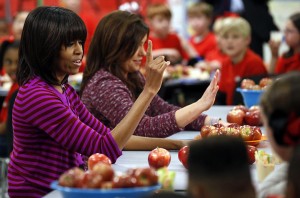 FILE - This Feb. 27, 2013 file photo shows first lady Michelle Obama and Food Network chef Rachael Ray discussing lunches with students from the Eastside and Northside Elementary Schools in Clinton, Miss. Moving beyond the lunch line, new rules expected to be proposed by the White House and the Agriculture Department Tuesday, Feb. 25, 2014, would limit marketing of unhealthy foods in schools, phasing out the advertising of sugary drinks and junk foods around school campuses and ensuring that other promotions in schools are in line with health standards that apply to school foods. (AP Photo/Rogelio V. Solis, File)