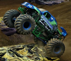 Stinger, a monster truck designed to look like it has a scorpion’s stinger in the back, drives over a number of cars during a monster truck rally. Stinger will be competing in Waco.