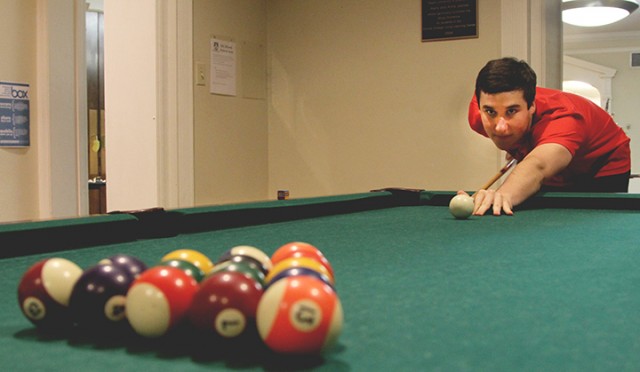 Freshman Tyler Wilson takes a study break and plays pool with friends in Alexander Hall. Midterm exams are right around the corner for Baylor students. Luckily, spring break is near, too. Carlye Thornton | Lariat Photographer