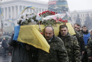 A coffin with the body of a protester killed in clashes with the police  is carried through the crowd Monday in Independence Square, Kiev. The United States and its allies in Europe are attempting to pressure Russia to reverse its military incursion into Ukraine, even as Moscow’s troops dig in in parts of this former Soviet country after Kiev decided to oust the pro-Russia president. 