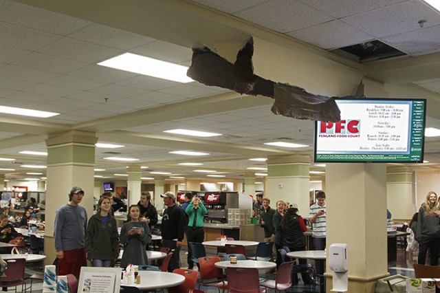 Students gather around a collapsed portion of the ceiling in the Penland Food Court. The roof leaked briefly before blowing out under the weight of rain and sleet. Kevin Freeman | Lariat Photographer