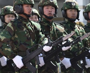In this Tuesday, March 31, 2009 file photo, soldiers from the People's Liberation Army (PLA) 6th Armored Division carries the Chinese type 97 semi-auto machine guns march at their military base on the outskirts of Beijing. China’s boosted defense spending this year grew 12.2 percent to $132 billion, continuing more than two decades of nearly unbroken double-digit percentage increases that have afforded Beijing the means to potentially alter the balance of power in the Asia-Pacific. Outside observers put China’s actual defense spending significantly higher, although estimates vary widely. (AP Photo/Andy Wong)