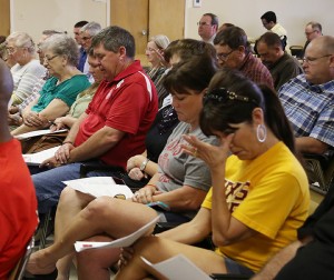People attending the West Fertilizer Explosion and Fire public meeting, bow their heads during a moment of silence at the Southside community center, Tuesday, April 22, 2014, in West, Texas. The deadly explosion in West a year ago was preventable and resulted from unsafe storage practices by West Fertilizer Co., and government oversight, U.S. Chemical Safety Board leaders said earlier in the day. (AP Photo/Waco Tribune Herald, Rod Aydelotte)