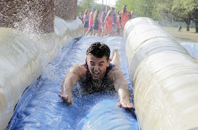 Denver, Colo. freshman Neville Schwinn does a head first slide down a water slide at the Zeta Tau Alpha crush event, called "Watercrush", on Wednesday, April 23, 2014 at Fountain Mall. Travis Taylor | Lariat Photo Editor