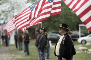 Bill Mahon, a member of the American Legion Unit 121 from Elm Mott, holds an American flag at the entrance to the 4-17 Forever Forward event, which commemorated the first anniversary of the West fertilizer plant explosion, on Thursday, April 17, 2014. Travis Taylor | Lariat Photo Editor