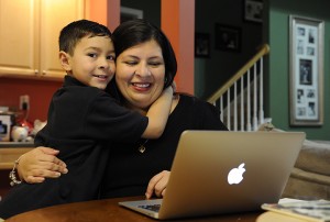 Marisela Martinez-Cola, right, a lawyer and a parent living in an Atlanta suburb with her husband Greg and their 7-year-old son, David, left, gets ready for a typical day Tuesday, in Lawrenceville, Ga. She sends her son to private school and has hired a tutor to improve his reading expenses made possible by her husband’s salary.Assoicated Press