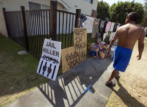 This July 25, 2012 file photo shows a neighbor walking past a memorial for police shooting victim Manuel Angel Diaz, 25, in Anaheim, Calif. Diaz was shot and killed by Anaheim police on Saturday. The killing of an unarmed black man by an officer in a nearly all-white police department in suburban St. Louis refocused the country on the racial balance between police forces and the communities they protect. But an analysis by The Associated Press found that the racial gap between black police and the communities where they work has narrowed over the last generation, particularly in departments that were once the least diverse. A much larger disparity now divides the low number of Hispanic officers in police departments. In Waco, Texas, for example, the community is more than 30 percent Hispanic, but the police department of 231 fulltime sworn officers has only 27 Hispanics.Damian Dovarganes |Associated Press