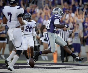 Kansas State running back Charles Jones (24) gets past Stephen F. Austin defensive back Demundre Freeman (26) and Hipolito Coporan (7) to score a touchdown during the first half of an NCAA college football game Saturday, Aug. 30, 2014, in Kansas City, Mo. (AP Photo/Charlie Riedel)