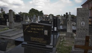 This July 28, 2014, photo shows Jakob Denzinger's portrait on the tombstone of his empty grave in Cepin eastern Croatia. Denzinger is among dozens of death camp guards and suspected Nazi war criminals who collected millions of dollars in Social Security payments despite being forced out of the United States.Associated Press