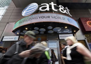 People pass an AT&T store Tuesday in New York’s Times Square. The government is suing AT&T over allegations it misled millions of smartphone customers.Associated Press