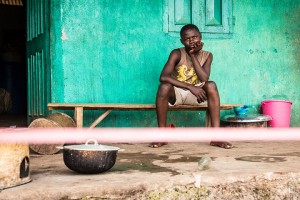 A youth under quarantine sits behind a cordon Wednesday outside his house in Moyamba town on the outskirts of Freetown, Sierra Leone.Associated Press